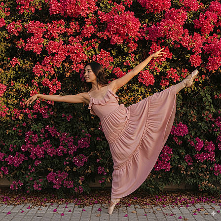 Elegante Ballettpose im rosa Kleid vor Bougainvillea – Tanz und Ästhetik
